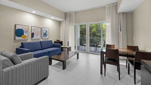 A modern living room with a sofa, coffee table, and dining area. - Heart of Downtown Doral – Resort Style Studio (Miami)