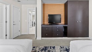 A hotel room with a bed, a TV on a wooden cabinet, a wardrobe, and a carpeted floor. - Studio for 5, Downtown Doral, kitchen & parking (Miami)