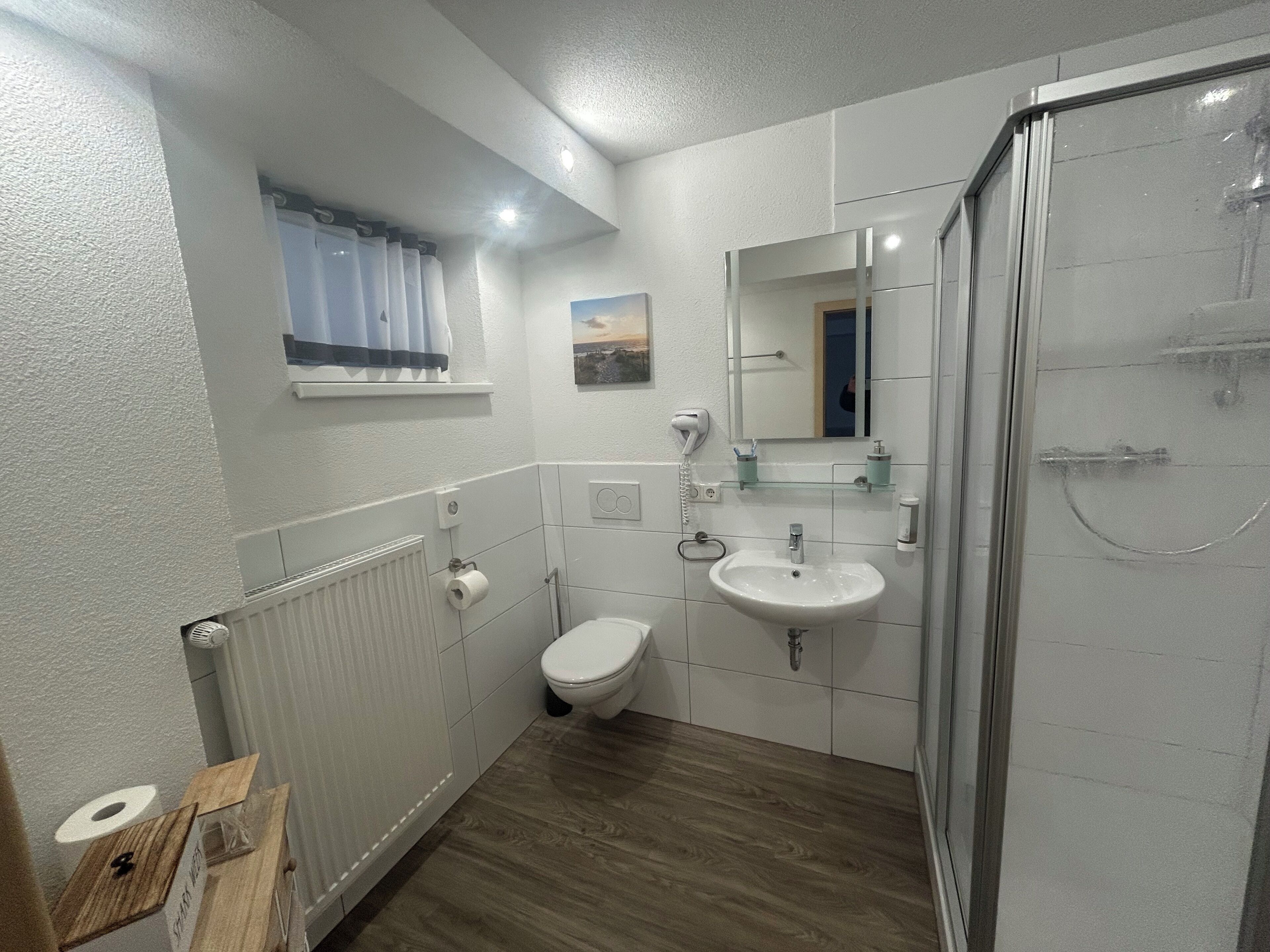 Un baño moderno con inodoro, lavamanos y ducha.