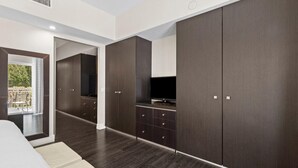 A modern bedroom with a large wardrobe, a television, and a balcony view.