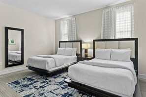 A hotel room with two beds, a large mirror, and a patterned rug. - Doral Studio 1070sq ft, Kitchen, Parking, Pool (Miami)