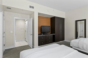 A hotel room with a bed, a TV on a wooden cabinet, a wardrobe, and a mirror.