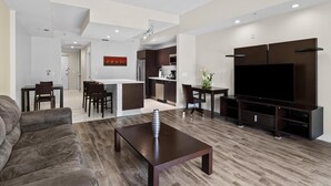 A modern living room with a sofa, a coffee table, a TV, and a kitchen in the background. - Grab your friends-3 Bed/4 Bath Villa in Doral-Miami (Miami)