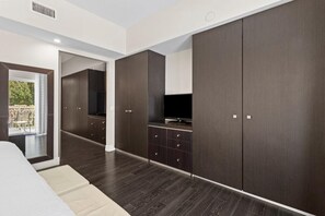 A modern bedroom with a large wardrobe, a television, and a balcony view.