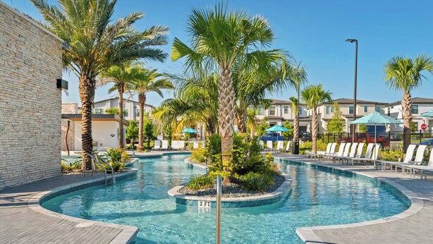 A swimming pool with palm trees, lounge chairs, and umbrellas. - 12BR house with private pool in Paradiso Grande (Orlando)