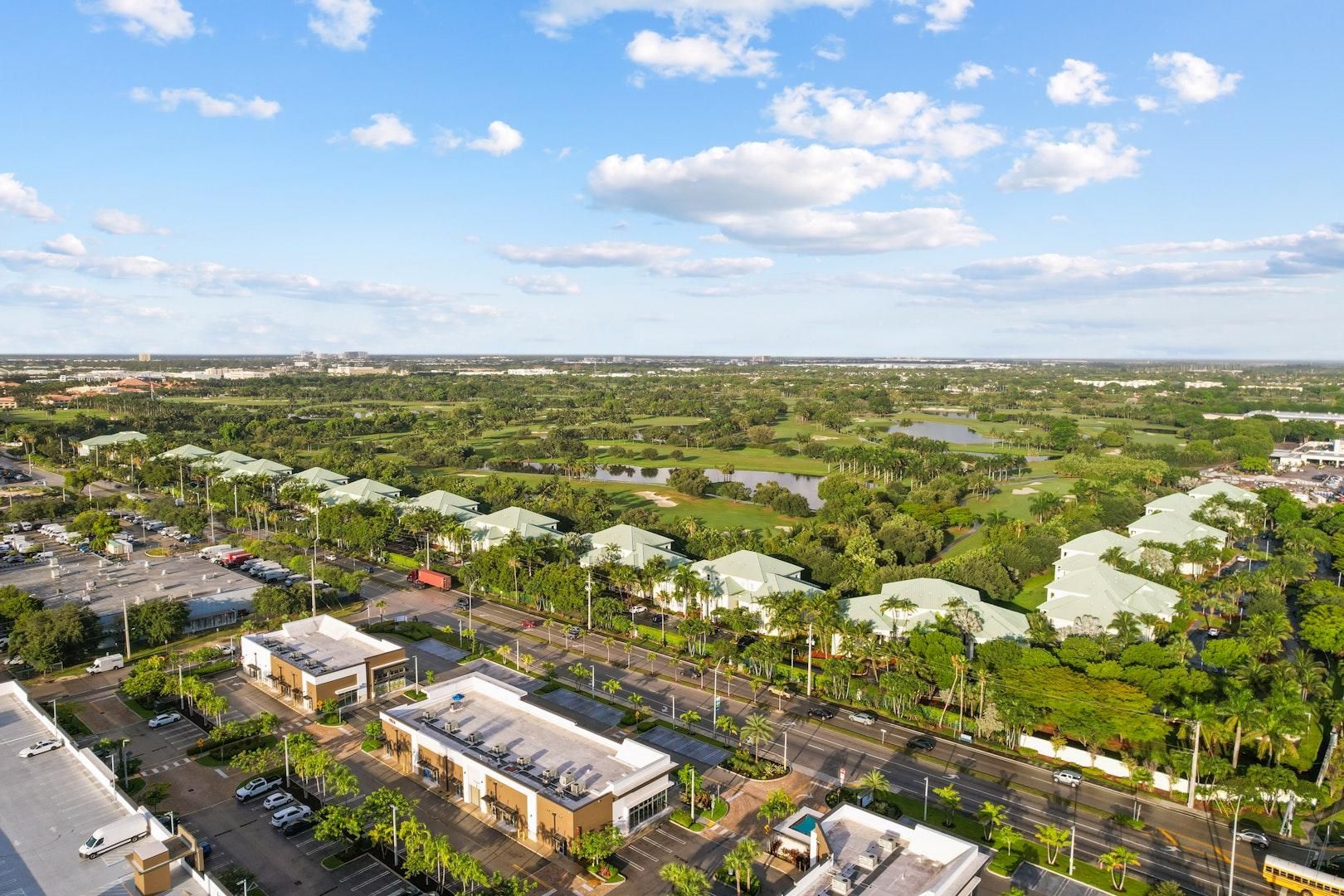 Luchtbeeld van een woongebied met meerdere gebouwen, wegen en groenstroken.