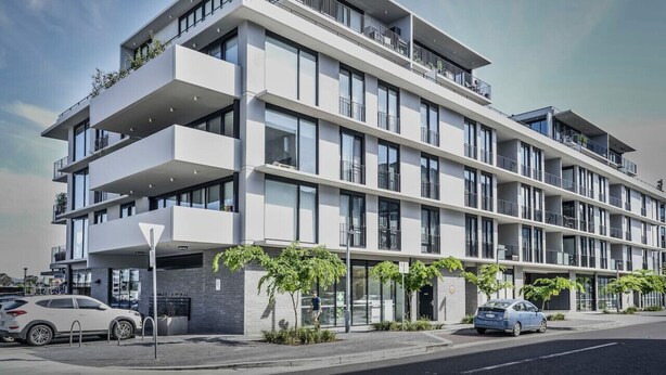 Un edificio moderno de varios pisos con balcones y ventanas amplias.