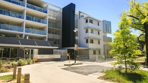 Een modern appartementencomplex met meerdere balkons en een bord waarop 'ENVY Apartments 35 Torne St' staat.