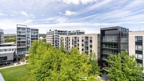 Ein moderner Gebäudekomplex mit mehreren Hochhäusern, Balkonen und großen Fenstern.