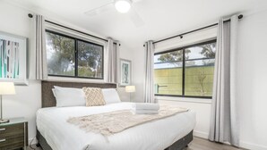 Una camera da letto moderna con un letto grande, due comodini e una ventola a soffitto.