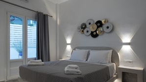 Ein modernes Schlafzimmer mit einem großen Bett, Nachttischlampen und einem Wandbild.