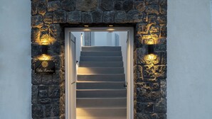 Ein steinrahmenartiger Eingang zu einer Treppe, mit einem Schild, auf dem 'Villa Bambos' steht.