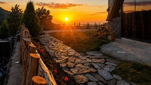 Une vue sur le coucher de soleil, prise depuis un bâtiment doté d’un chemin en pierre et d’une clôture en bois.