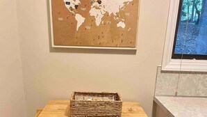 Un meuble en bois, avec une carte du monde accrochée au mur juste au-dessus.
