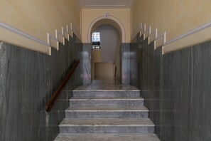 A marble staircase with a handrail leading to an archway. - Casa Gabri by Wonderful Italy (Turin)