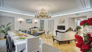 Een ruime woonkamer met een eethoek, stijlvol meubilair en een kroonluchter.