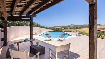 Una piscina al aire libre de temporada, tumbonas