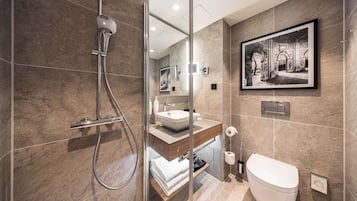 Ein modernes Badezimmer mit einer Duschkabine, einem Waschbecken und einer Toilette.