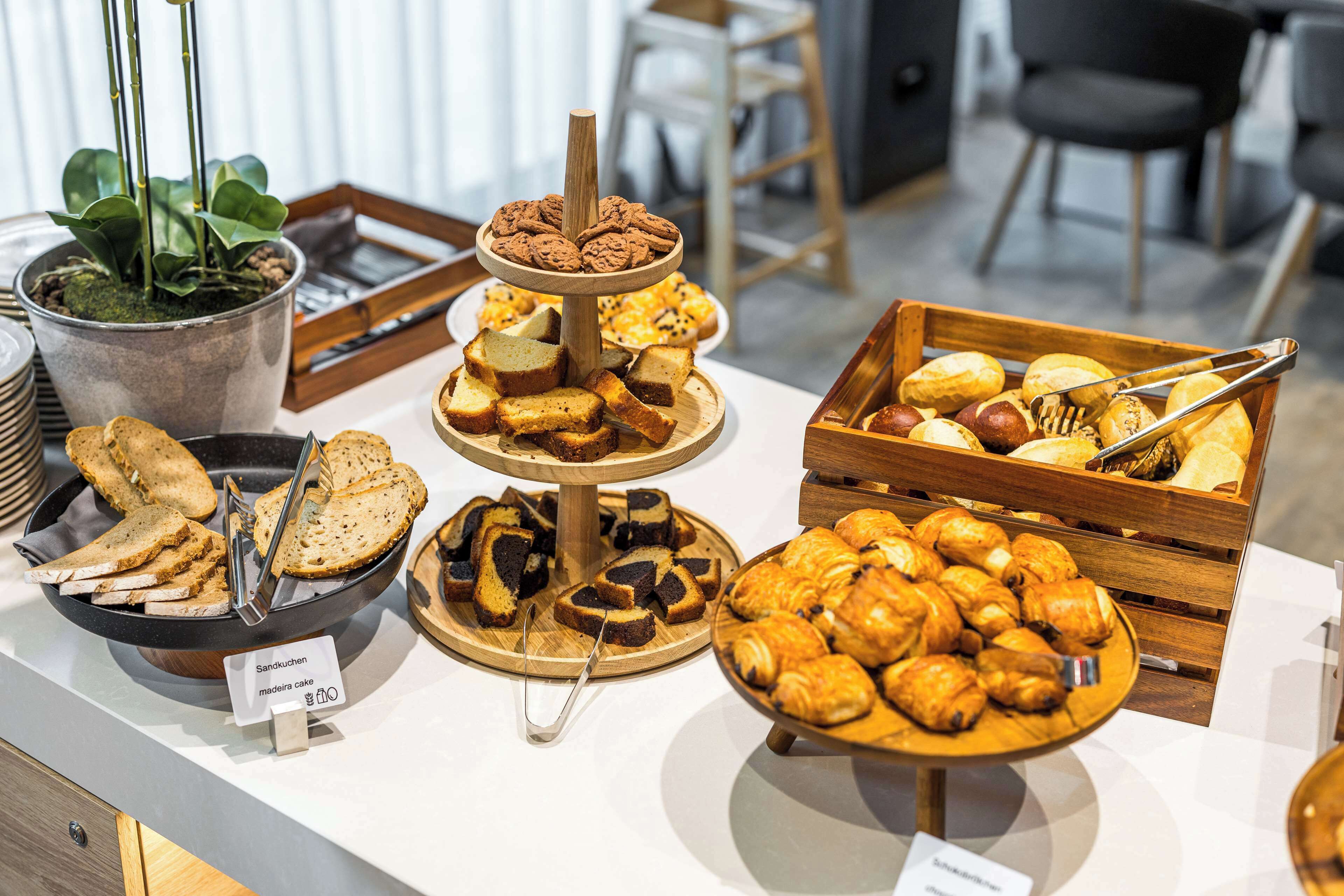 A buffet with various baked goods including bread, pastries, and cookies.