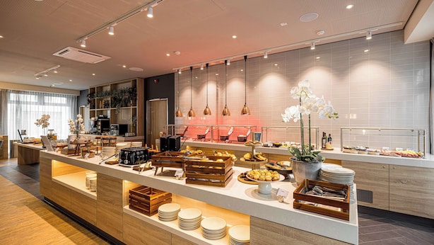 Buffet de l'esmorzar modern amb taulells de fusta, una varietat d'aliments i un interior net i ben il·luminat.