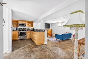 Open living area with blue sofa and kitchen breakfast bar.