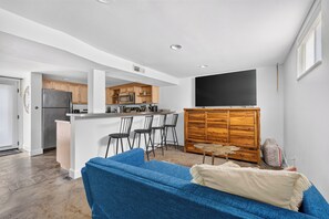 Open living area with blue sofa and kitchen breakfast bar.