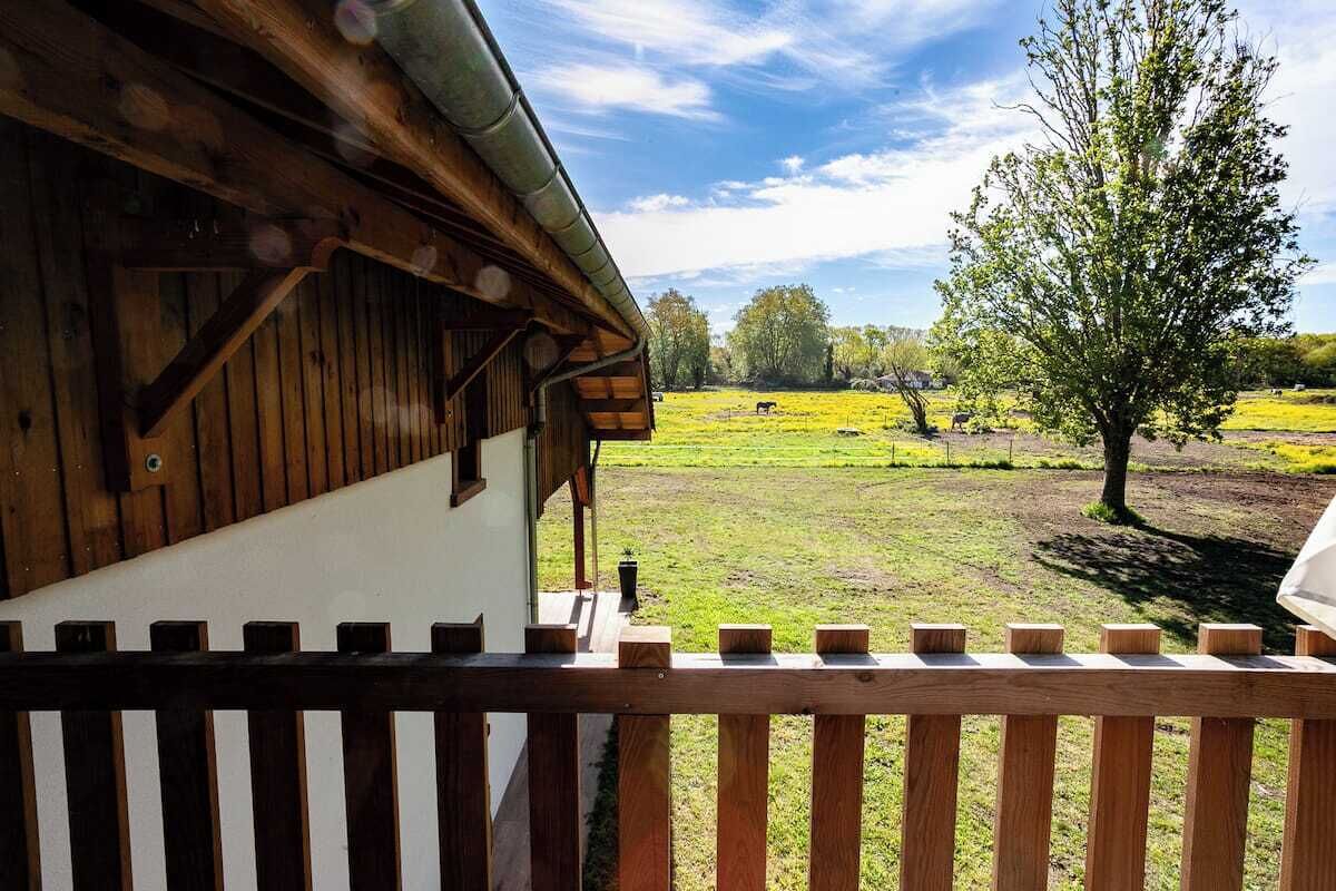 Un bâtiment en bois, doté d’un toit en pente et d’une clôture en bois au premier plan.