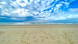 A beach with footprints in the sand and a cloudy sky. - Le Grenier in a magnificent forest park on the edge of the lake 8km to the ocean (Aureilhan)