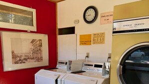 A laundry room with two washing machines, a clock, and a framed picture on the wall. - Quaint Riverside Cabin # 1 (Crowsnest Pass)