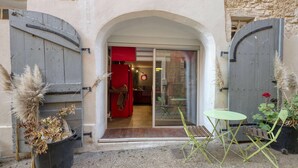 A rustic entrance with a wooden door, a glass door, and a small table with chairs.