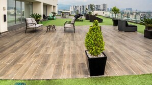 A rooftop terrace with outdoor seating, a small lawn, and a city view. - Elite 47 Unity (Huixquilucan)