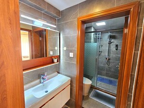 Apartemen Comfort, pemandangan kota | Kamar mandi | Shower, sandal, handuk, dan sabun