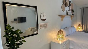 Une chambre à coucher comprenant un lit, des lampes de chevet, un miroir, une horloge et des étagères décoratives murales.