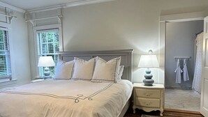 A bedroom with a large bed, bedside tables, a ceiling fan, and a view of the outside through the window. - Arden Cottage (Mount Vernon)