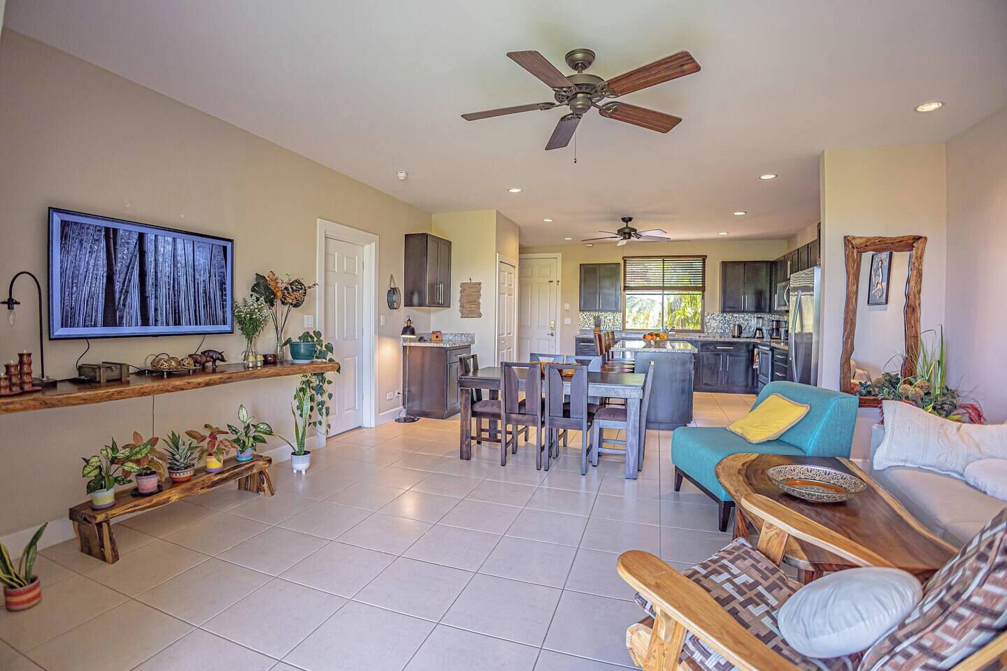 A spacious living room with a TV, dining area, and kitchen.