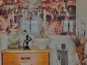 Experience the vibrant city scene in this room, featuring a stunning mural and natural touches.
