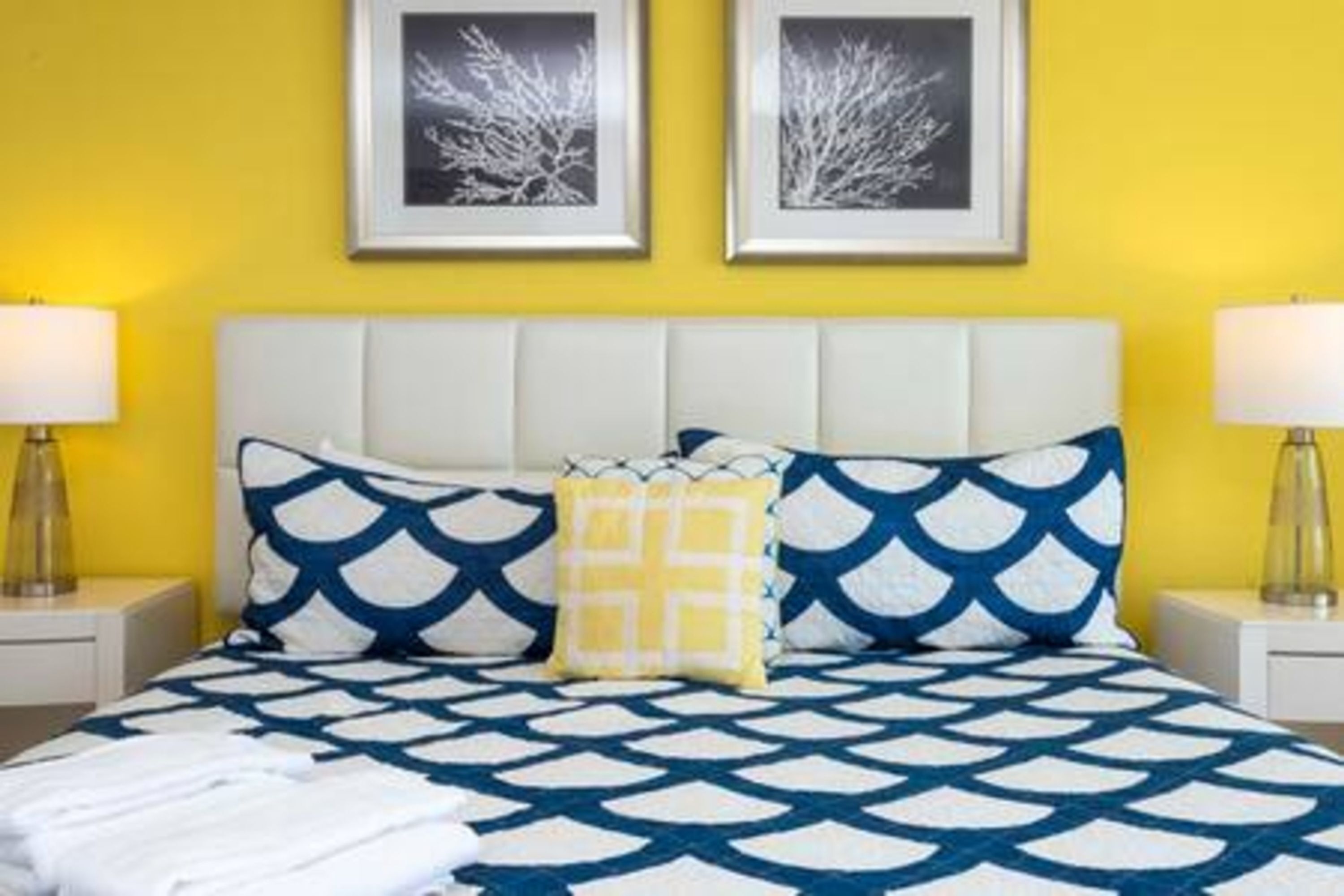 A hotel room with a bed, two bedside tables, and a headboard.