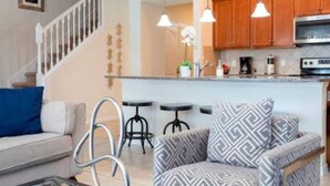 A modern kitchen with wooden cabinets, a stainless steel range hood, and pendant lighting. - Free Water Park Private Pool and Lakeview (Kissimmee)