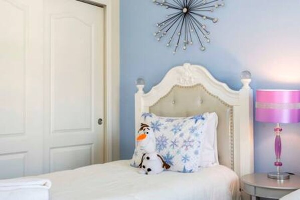 Une chambre à coucher avec un lit, une table de chevet, une lampe et un élément décoratif mural.