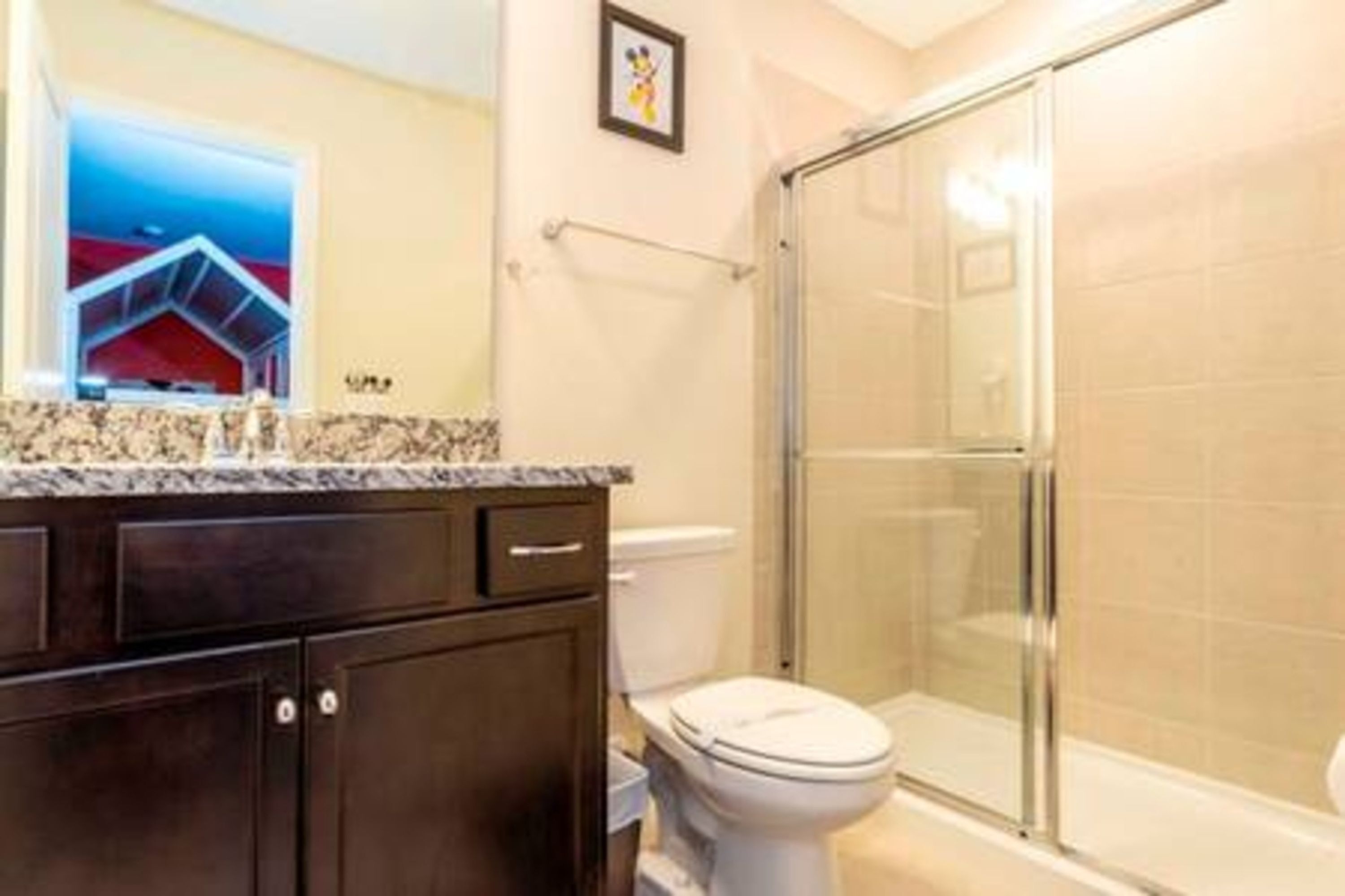 Une salle de bain équipée de toilettes, d’une douche et d’un comptoir en marbre.