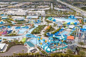 A water park with multiple slides and pools, surrounded by buildings and palm trees. - Brand NEW Private Oasis 4 BR - Margaritaville (Kissimmee)