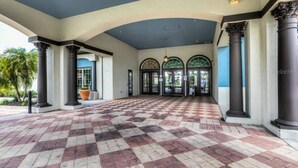 A covered outdoor area with a checkered floor, columns, and a blue ceiling. - 5 Suites - Game Room Theater Room Private Pool (Kissimmee)