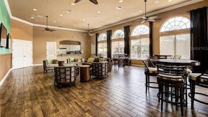 A spacious living area with a high ceiling, multiple ceiling fans, and large windows providing natural light. - 5 Suites - Game Room Theater Room Private Pool (Kissimmee)