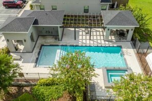 A residential property with a swimming pool, a covered patio, and a small garden area. - Beautiful 4 Bed 3 5 Bath With Jacuzzi (Kissimmee)