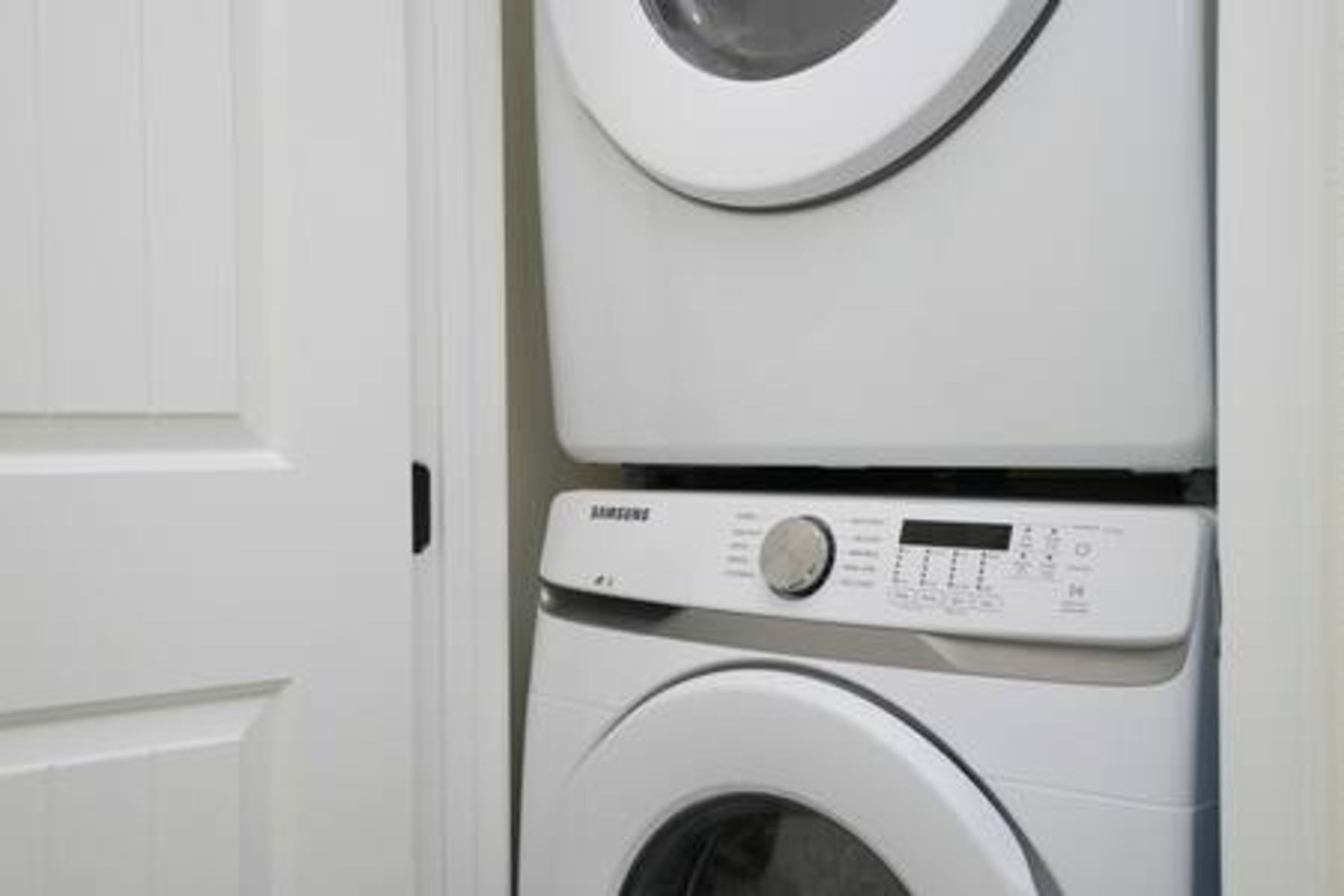 A stacked washer and dryer unit in a white interior.