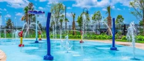 A water park with multiple water fountains and a clear blue sky.