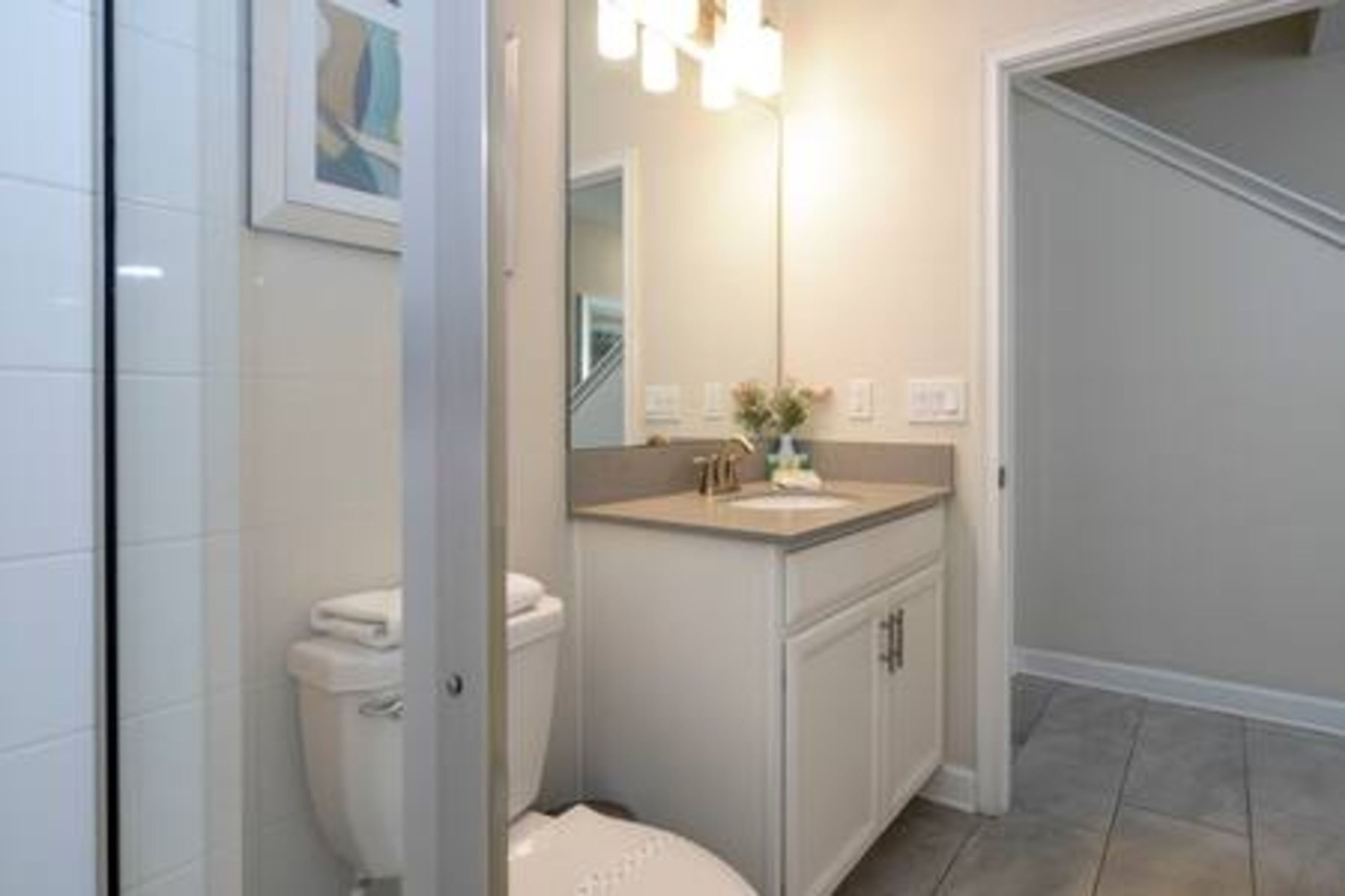 A bathroom with a toilet, sink, and cabinet.