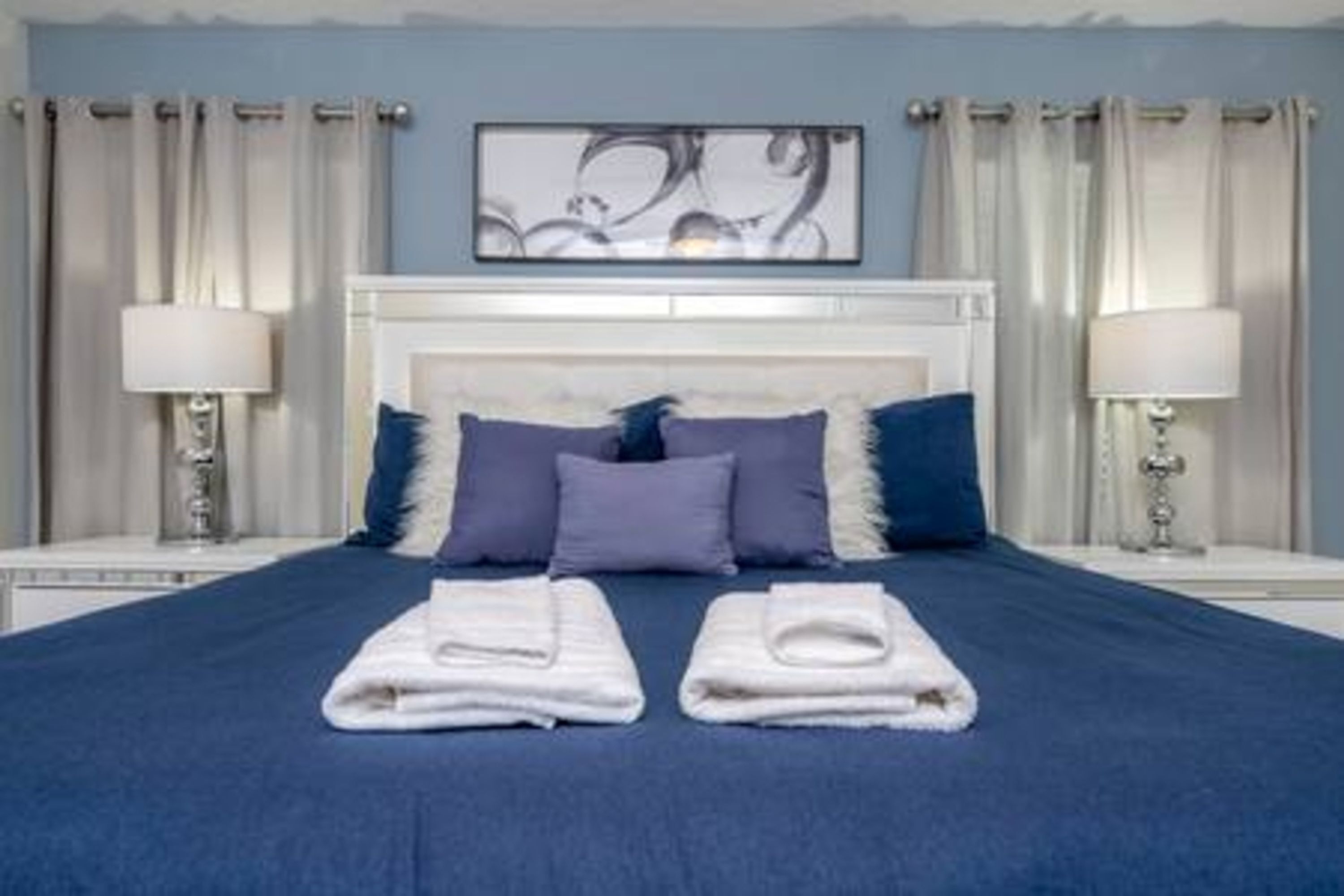 A hotel room with a large bed, two bedside tables, and a headboard.