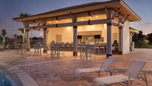 An outdoor pool area with lounge chairs and a covered seating area. - Fabulous 3 Bedroom With Game Room (Davenport)