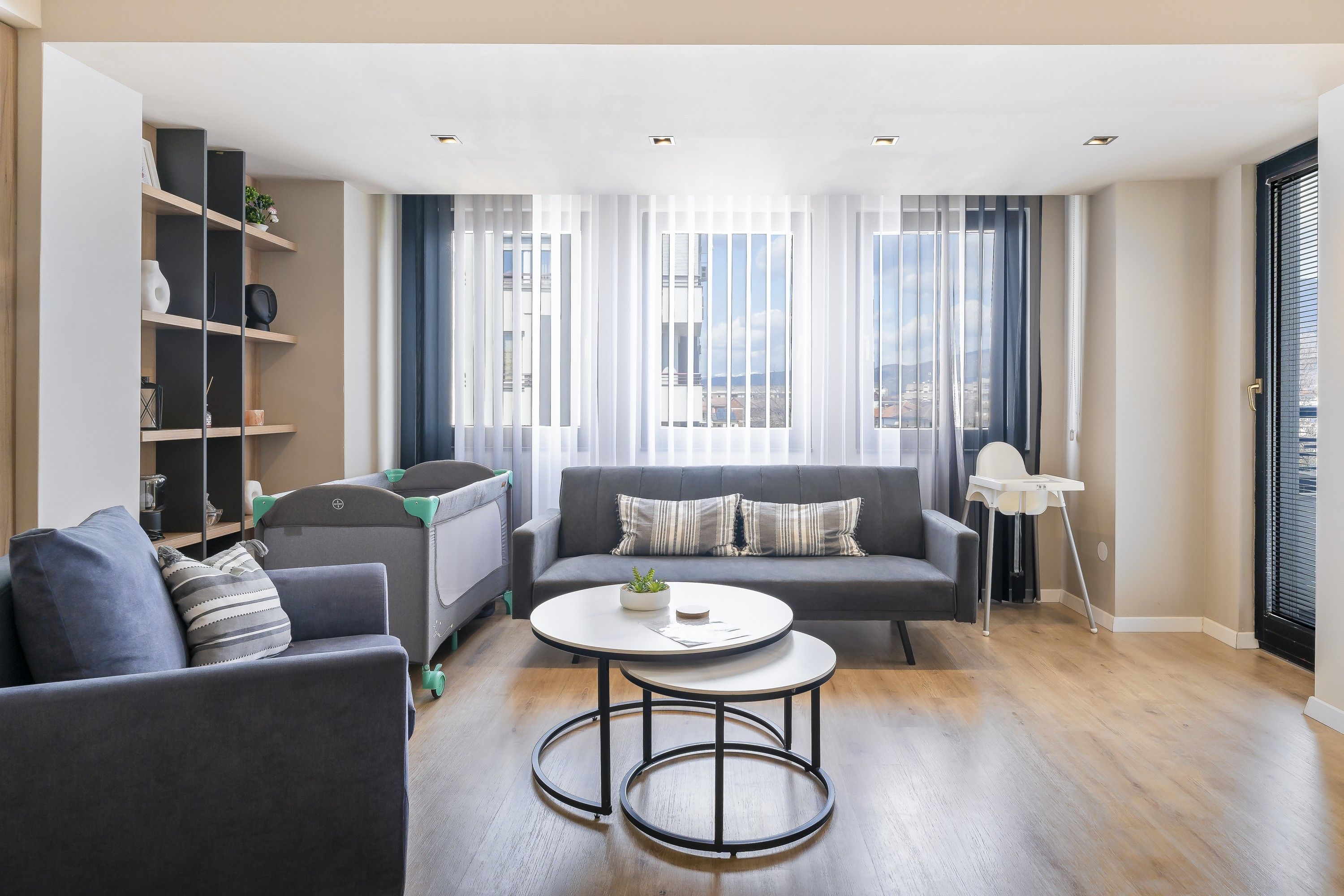 A modern living room with a sofa, a coffee table, and a bookshelf.